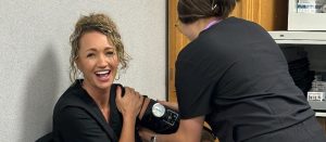 Medical assisting students practice taking blood pressure on each other