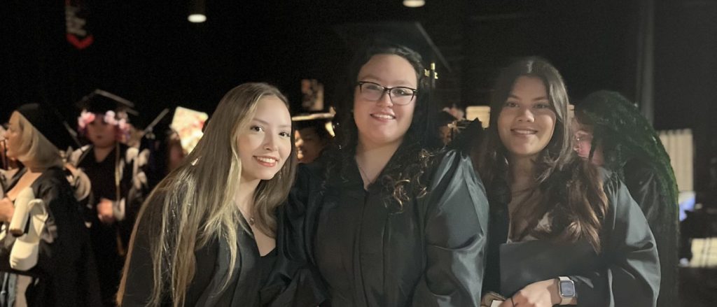 Three female graduates pose before the ceremony in San Antonio, TX