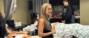 Students and prospective students listen to an educator in Palm Desert, California in the esthetician field.