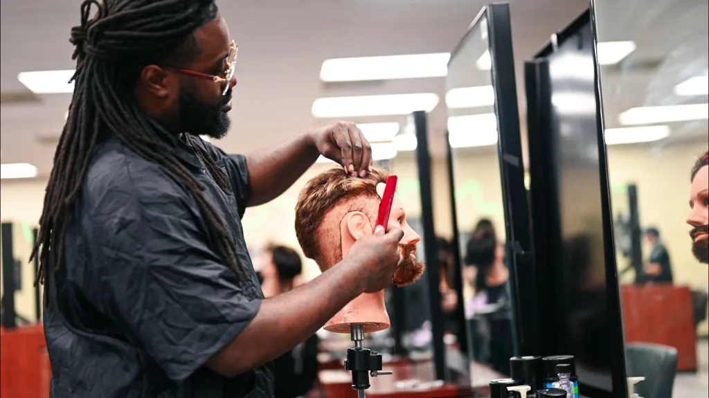 Barbering student in Clovis practices on a mannequin