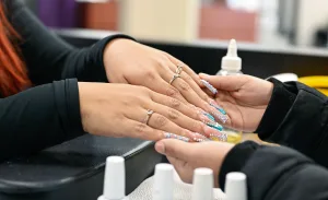 Nail Tech Students working on acrylic set in the student salon