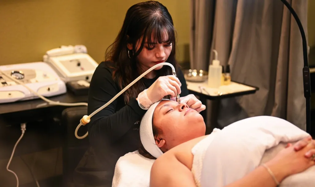 Esthetican student in Palm Desert works on her facial skills with a fellow student