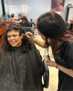 Milan Institute San Antonio Ingram students works their makeup skills as they pamper one of Eva's Heroes participants.